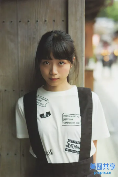 阿拉夫德亚裔女子靠在木墙上，穿着白衬衫