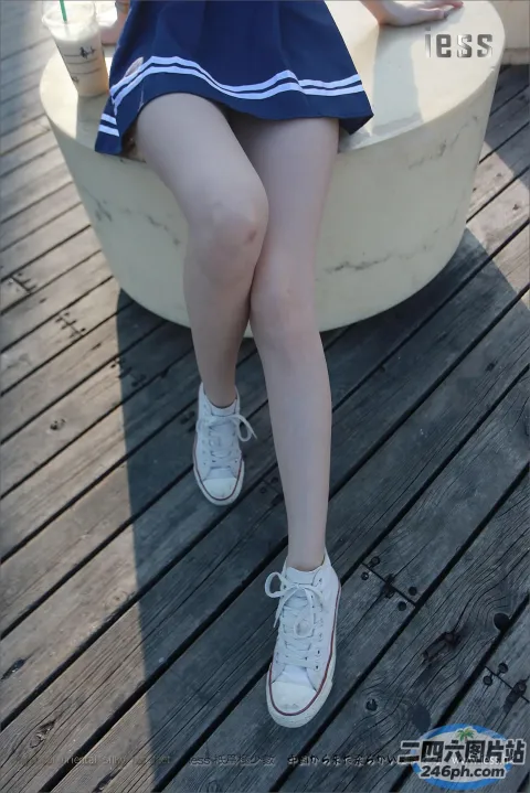 有个女人坐在长凳上，手里拿着一杯饮料