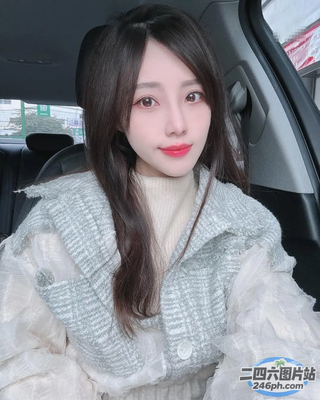车里坐着一个女人，手里拿着手机