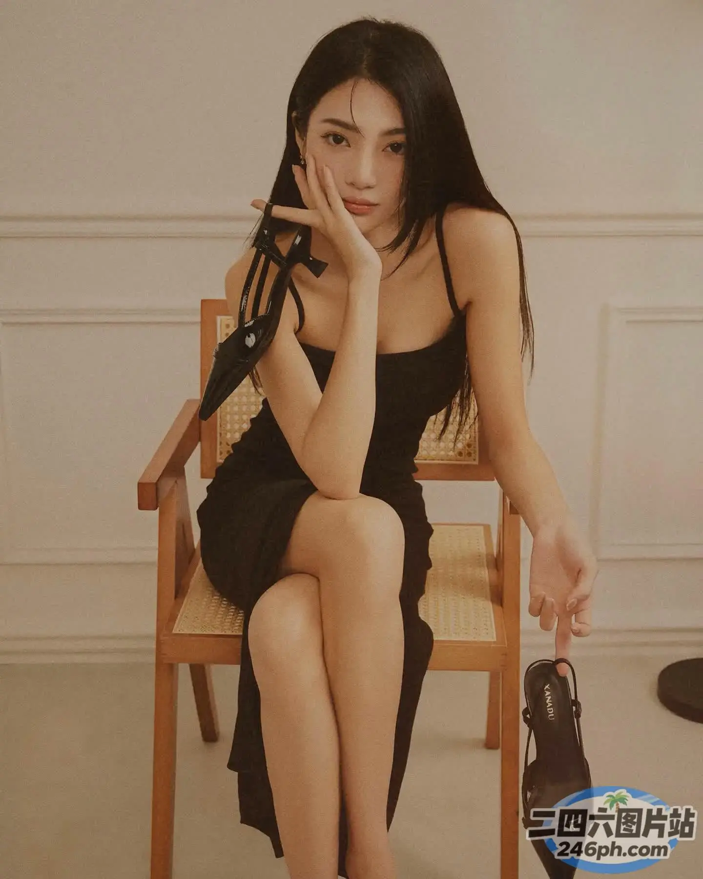 一个女人坐在椅子上拿着手机的特写
