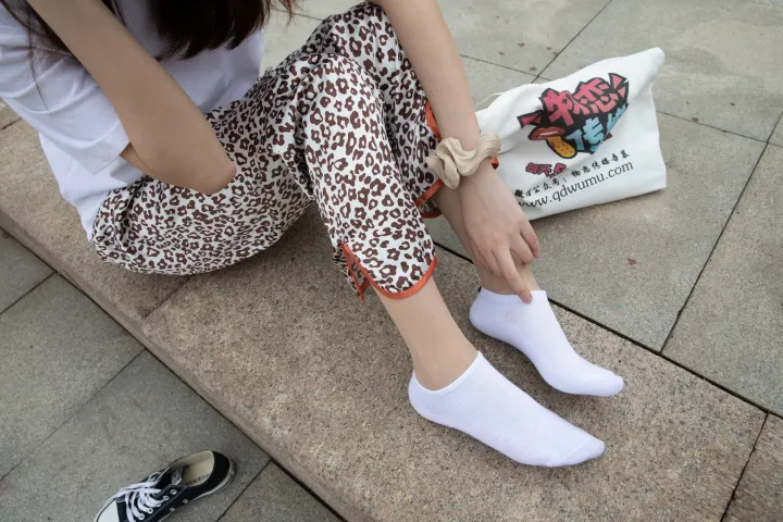 阿拉菲坐在地上，双脚放在一个袋子上