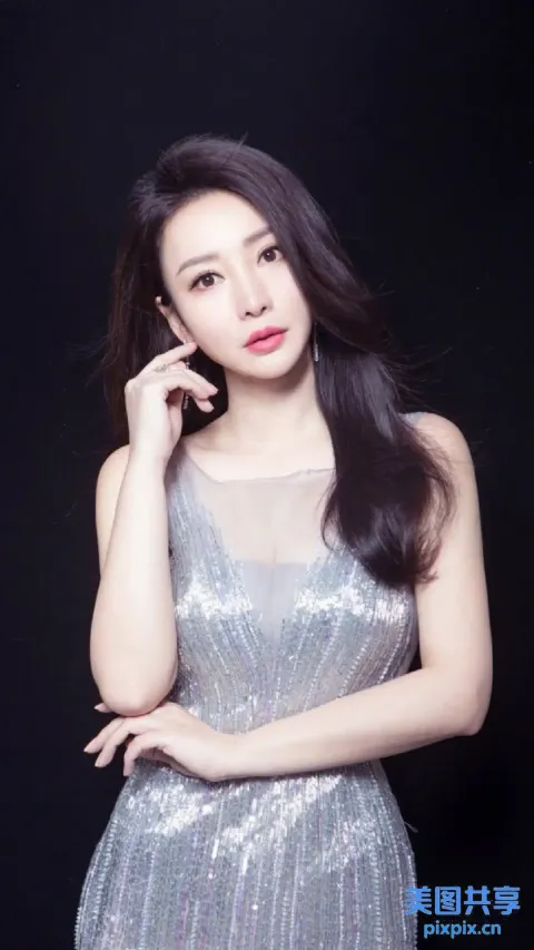 一个身穿银色连衣裙的女人用手机说话的特写