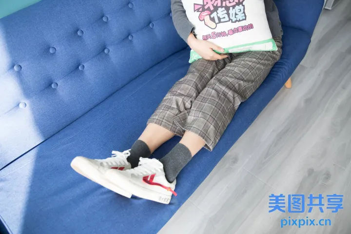 有一个男人坐在沙发上，上面放着一个枕头