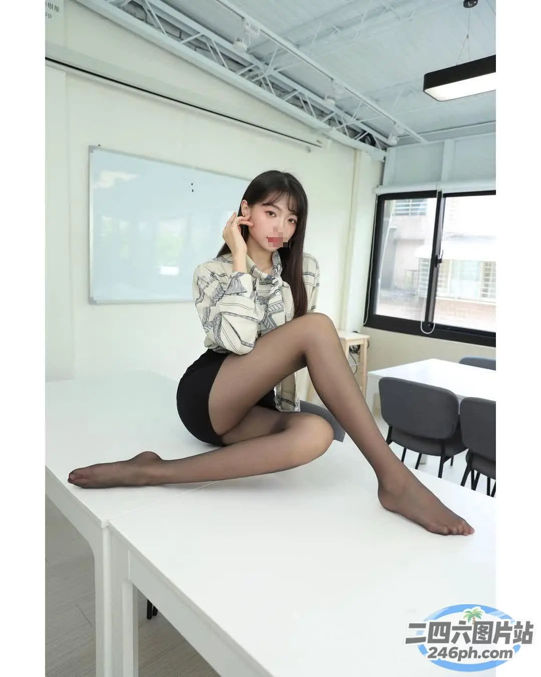 一个女人坐在桌子上拿着手机的特写
