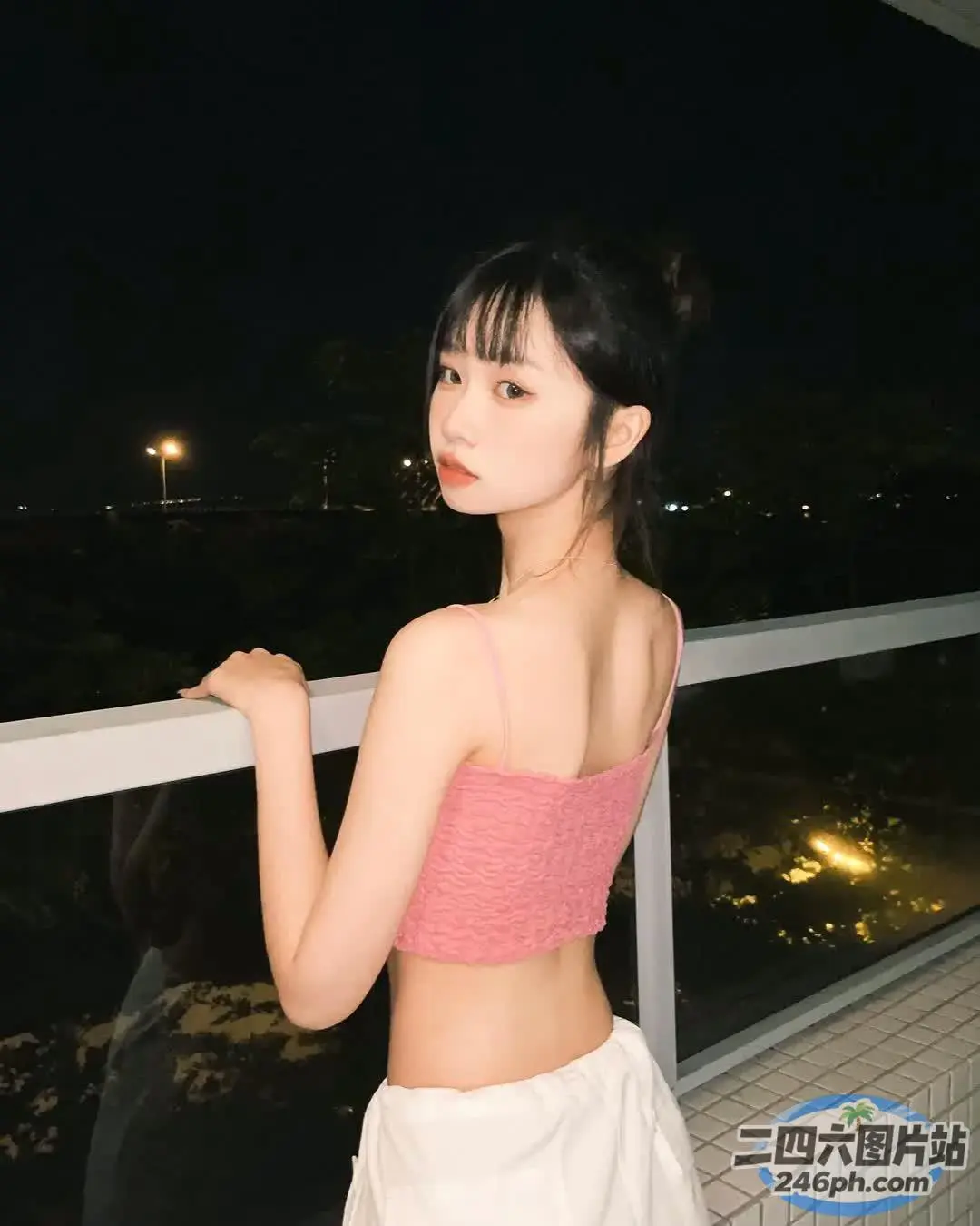 阳台上穿着粉红色上衣的女人的特写