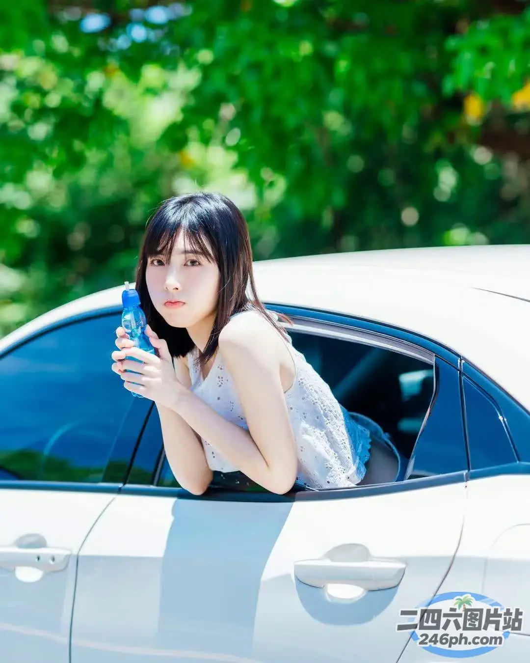 阿拉菲女子从车窗探出头来，手里拿着手机