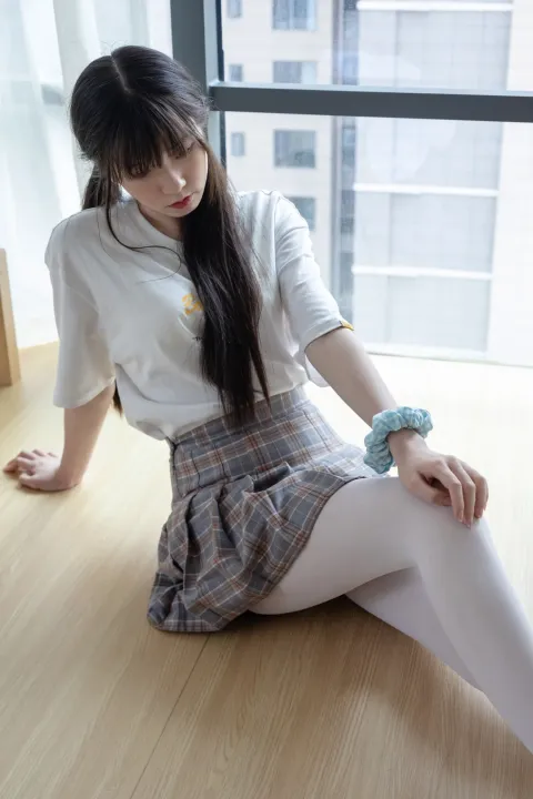 阿拉菲德亚洲妇女坐在地板上，手里拿着一个毛绒玩具