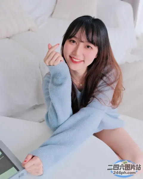 阿拉菲德女人坐在床上，手里拿着一台笔记本电脑