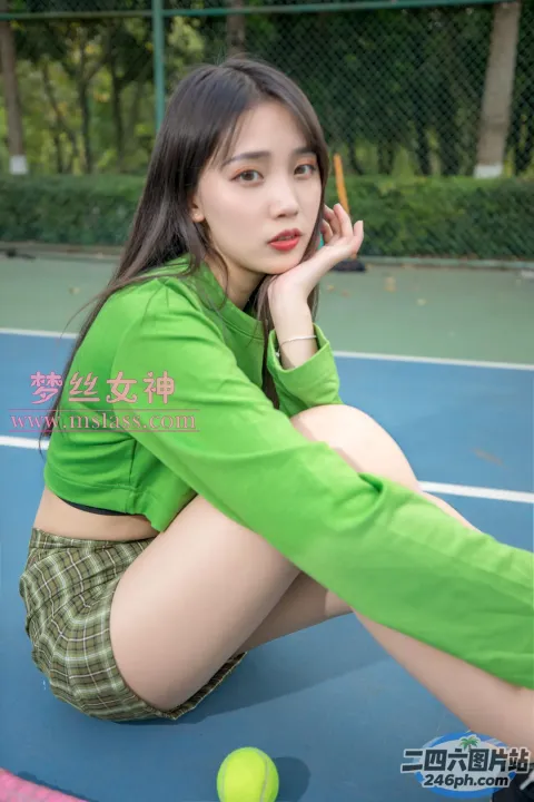 一个女人拿着网球坐在网球场上的特写
