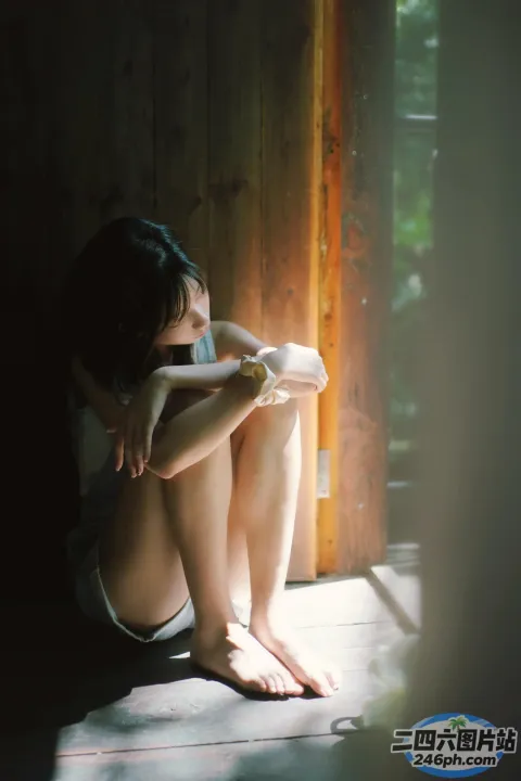 在黑暗的房间里，有一个女人坐在地板上