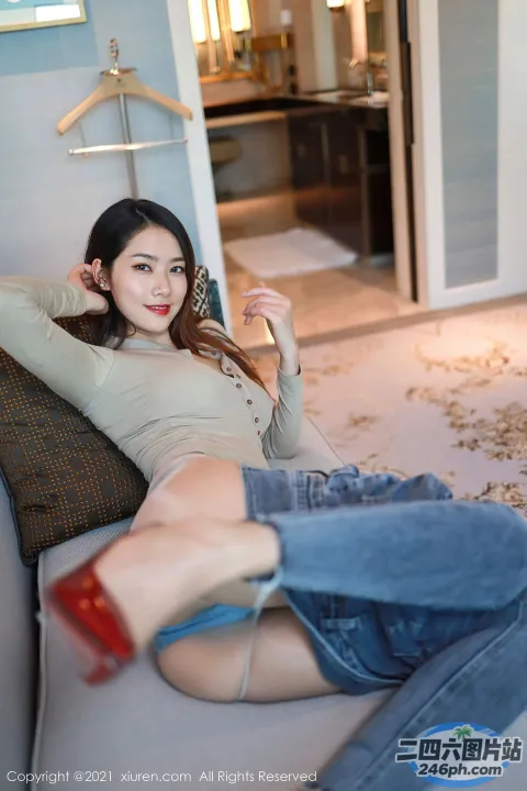坐在沙发上，手里拿着遥控器的 arafed 女人