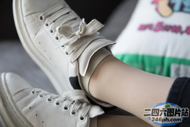 有人穿着白色运动鞋，上面有黑色鞋带