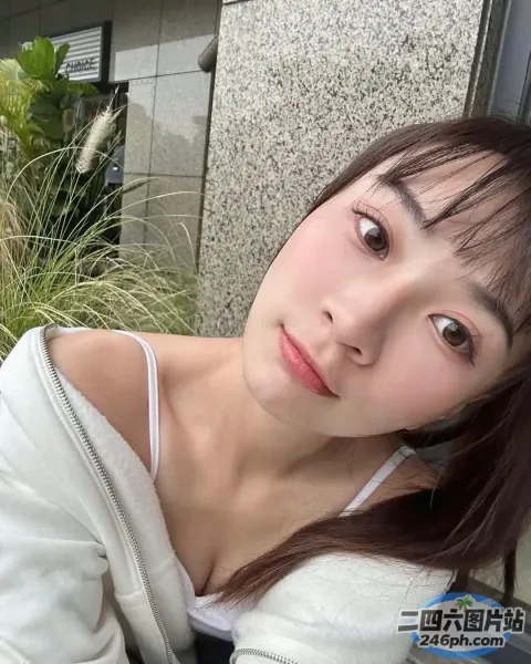 有一位女士在一栋建筑前摆姿势拍照