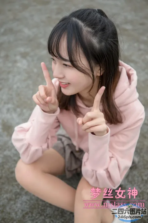 一名女子坐在地上，手指向上