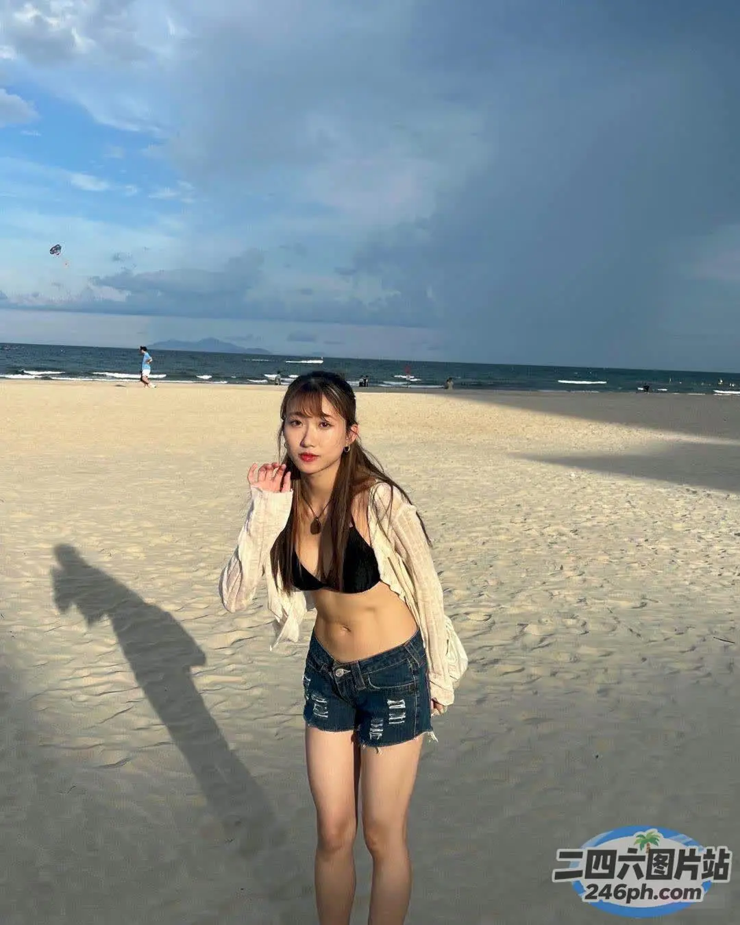 有个女人站在沙滩上用手机说话
