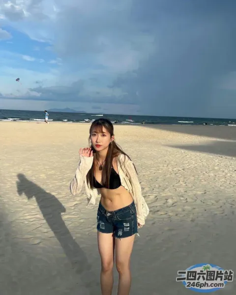 有个女人站在沙滩上用手机说话
