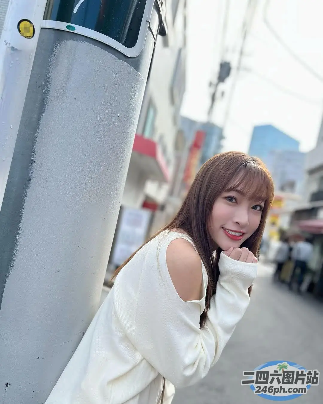 阿拉夫德亚裔妇女靠在城市的一根杆子上