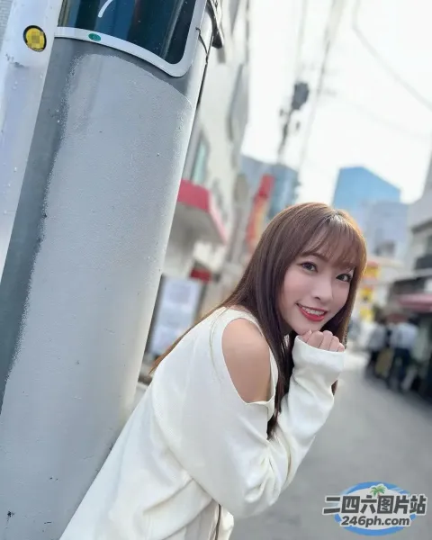 阿拉夫德亚裔妇女靠在城市的一根杆子上