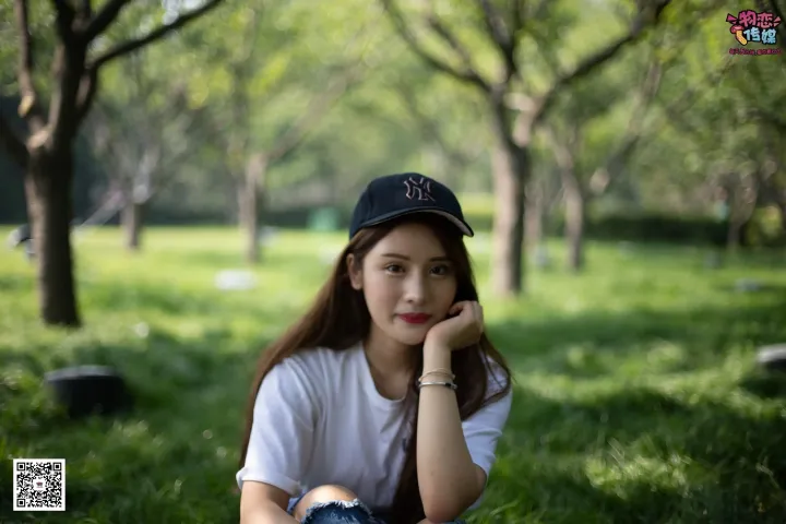 戴着棒球帽坐在草地上的阿拉夫德女人
