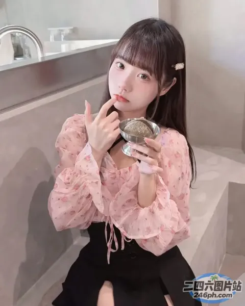 一个穿着粉红色衬衫的女人在浴室里刷牙