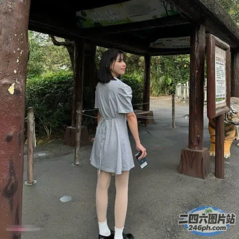 有个女人站在木结构前。
