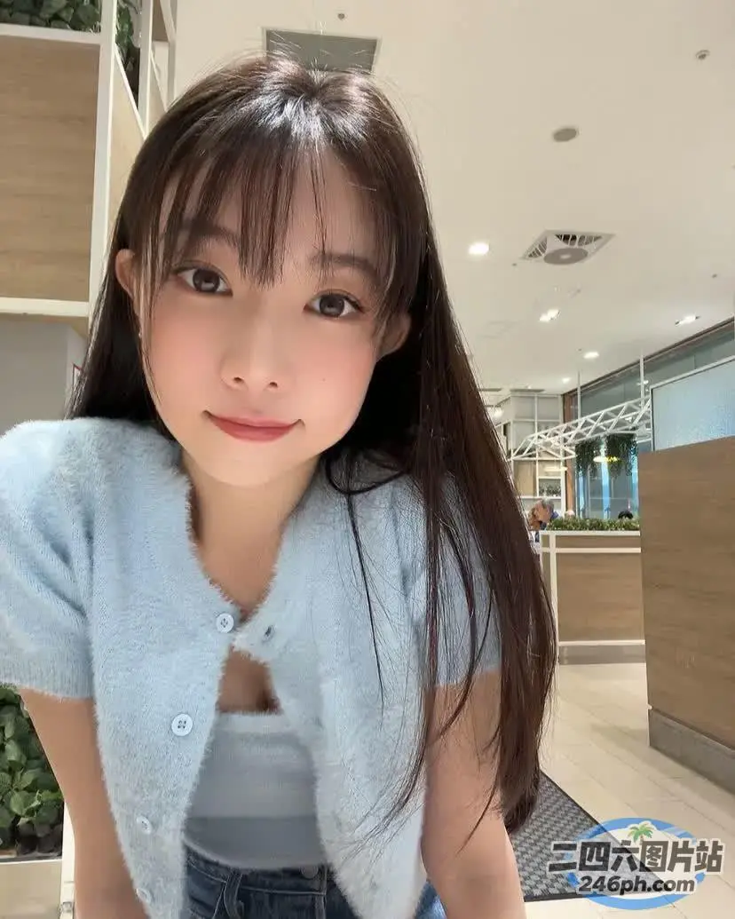 长发亚洲女性，穿着蓝色毛衣和牛仔裤