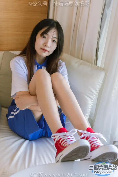 阿拉夫德亚洲妇女坐在床上，双腿交叉