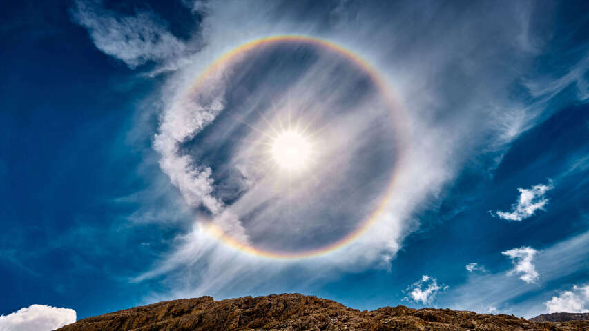 天空中彩虹的 arafed 图像，背景是一座山