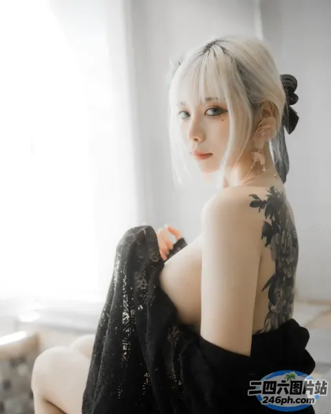 床上坐着一个背上有纹身的女人