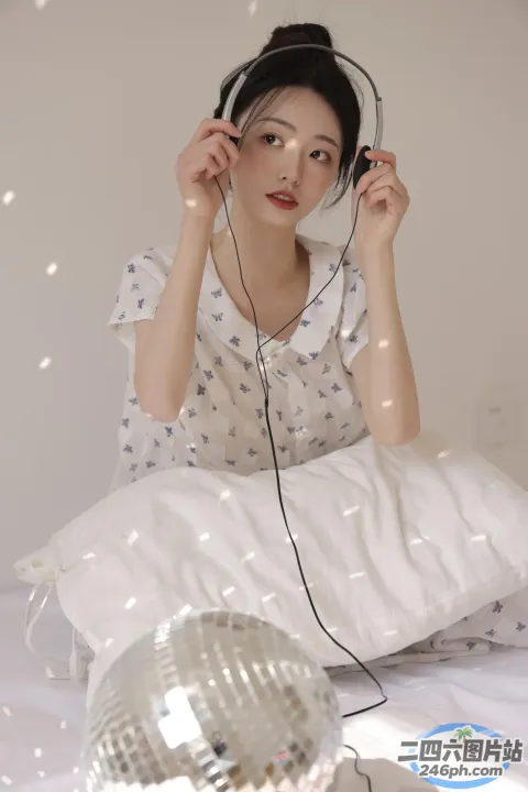 有个女人坐在床上，戴着耳机