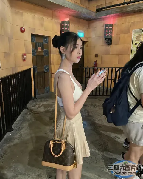 走廊上站着一个女人，手里拿着手机