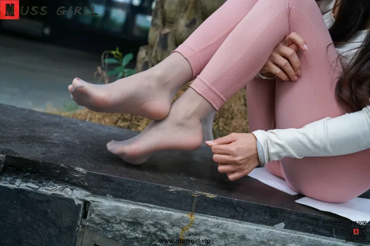 有一个女人坐在窗台上，脚踩在纸上
