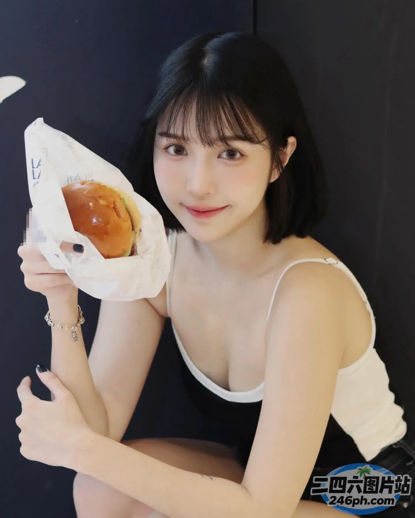 身穿黑色连衣裙的 araffe 女子拿着纸袋里的热狗