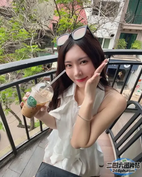 阿拉菲女人坐在阳台上，手里拿着饮料和吸管