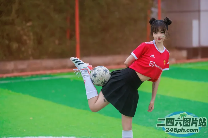 有一个年轻女孩在球场上踢足球