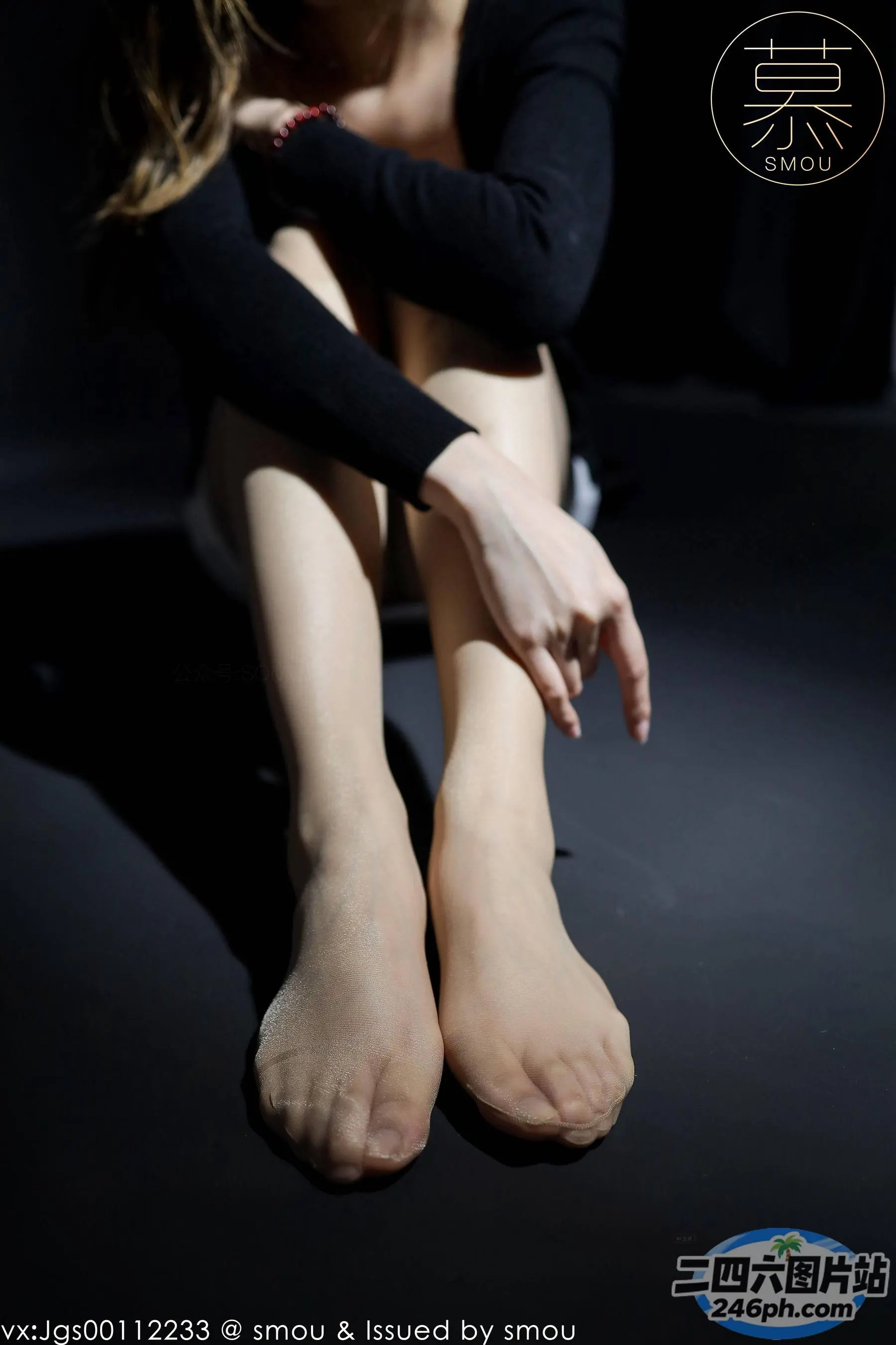 有一个女人坐在地板上，双腿交叉