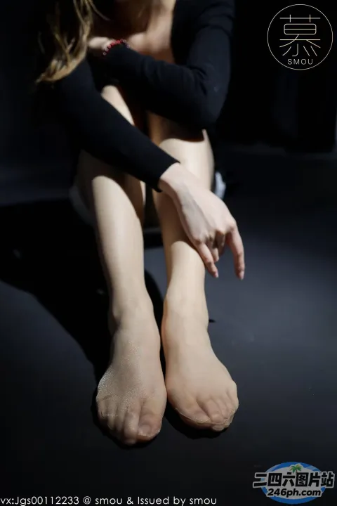 有一个女人坐在地板上，双腿交叉