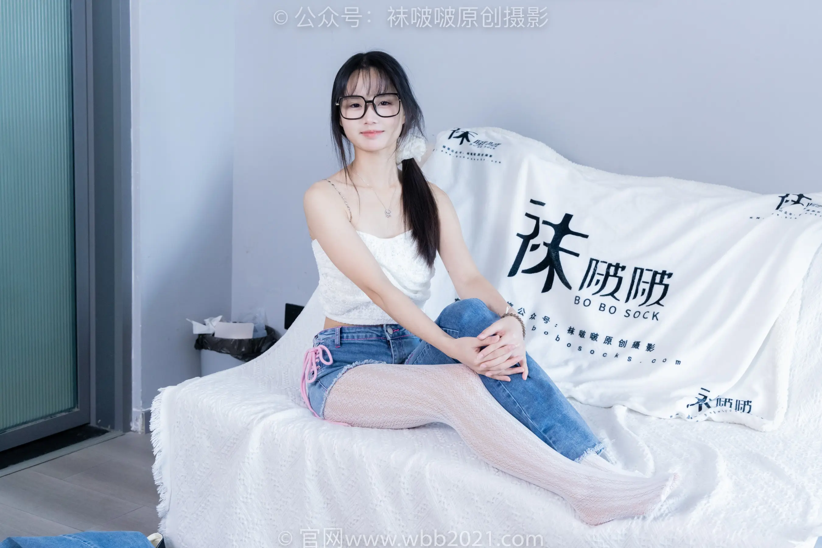 坐在床上的阿拉夫德女人，床上铺着白色的床单和白色的枕头