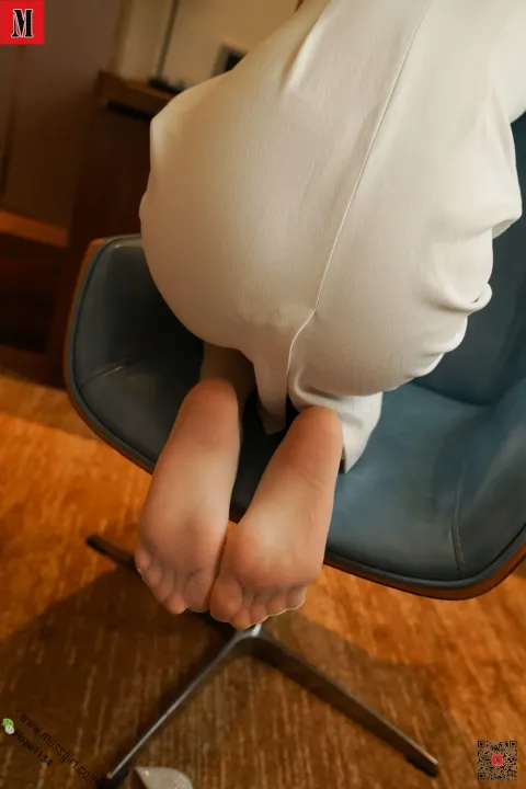 有个女人坐在椅子上，双腿交叉