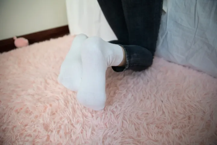 有人穿着白色袜子和一双黑色鞋子