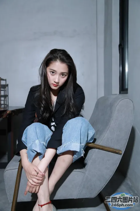 有一个女人盘着腿坐在椅子上