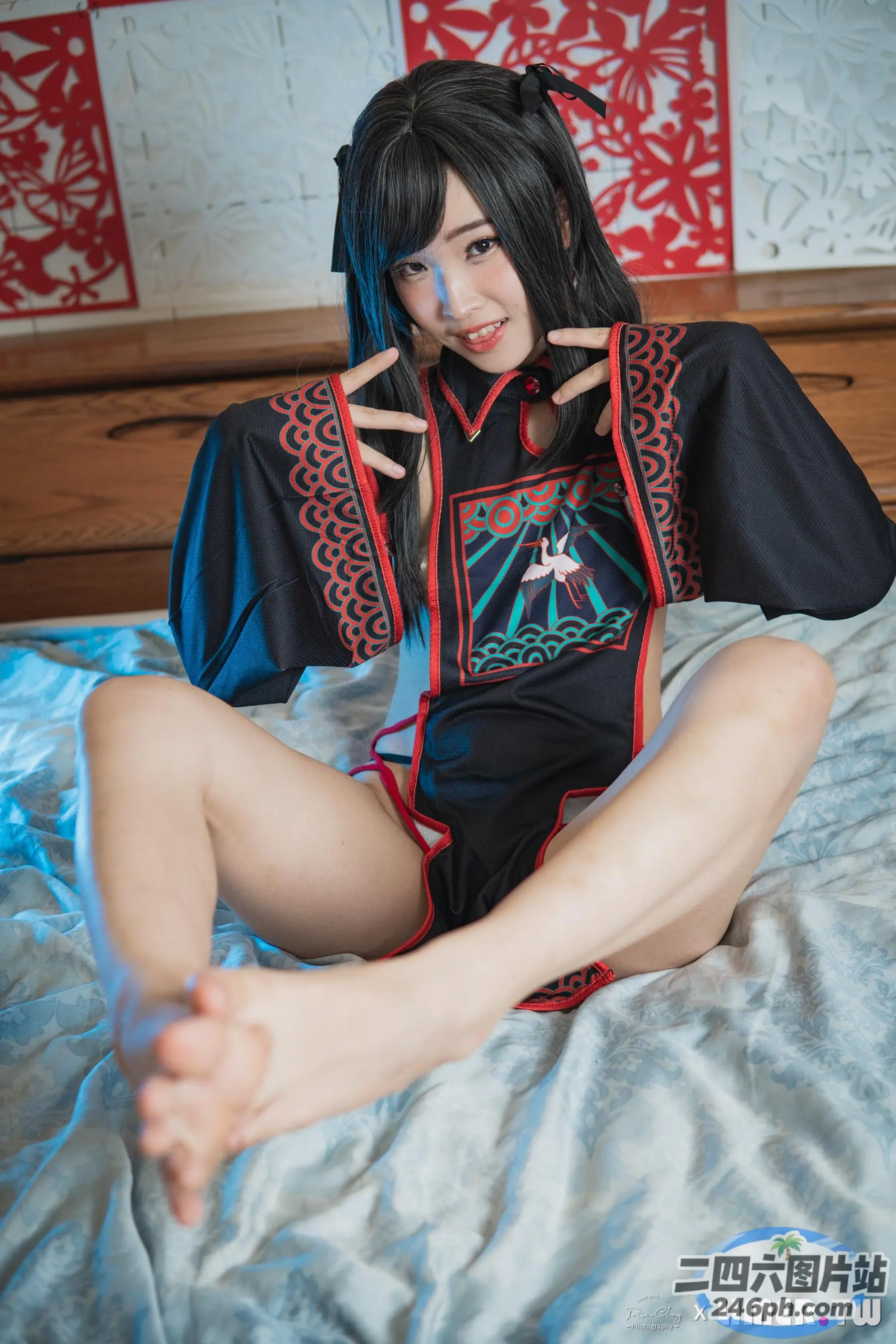 身穿黑红相间服装的阿拉夫德女子坐在床上