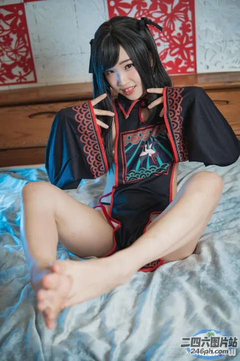 身穿黑红相间服装的阿拉夫德女子坐在床上