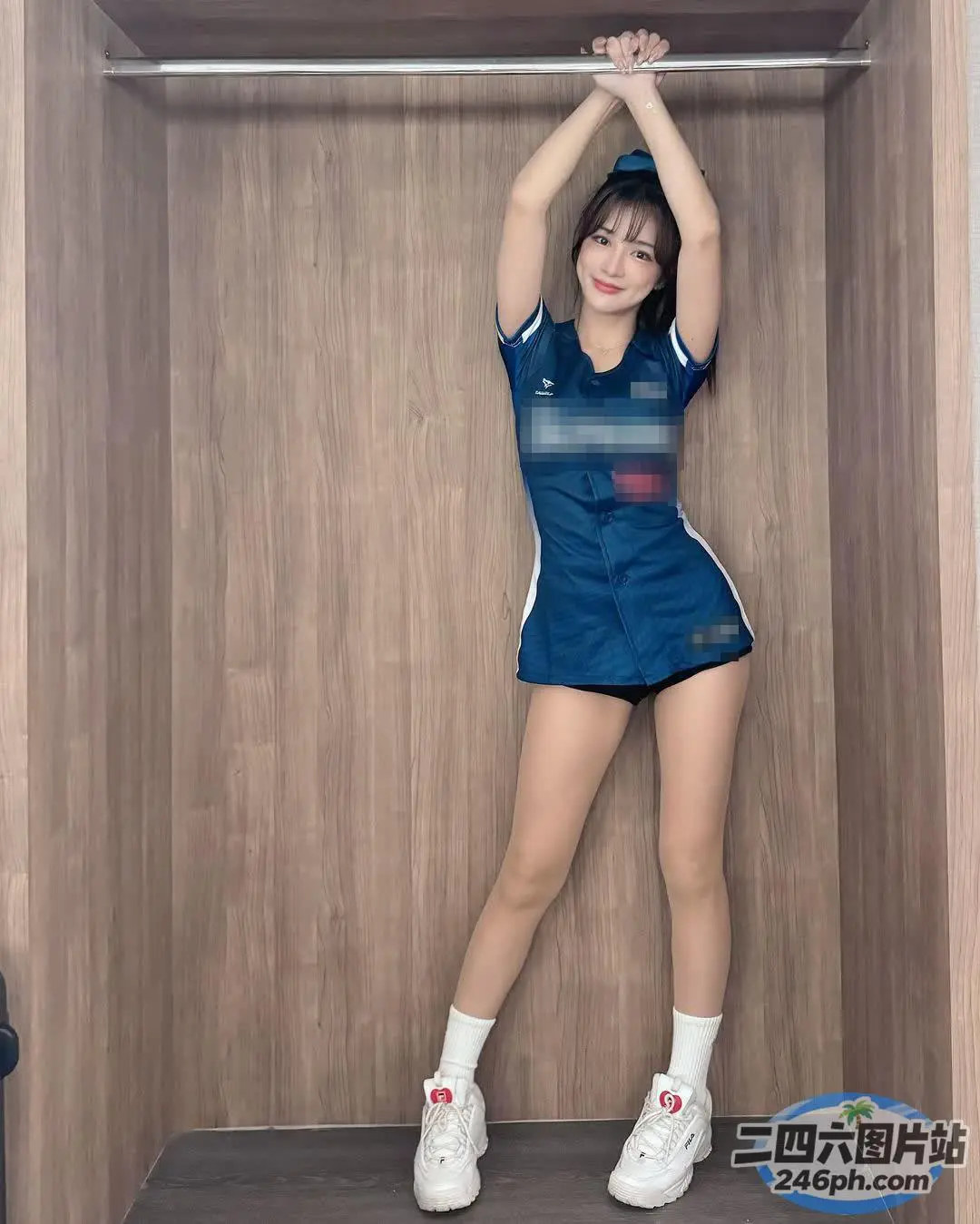 身穿蓝色连衣裙和白色运动鞋的 Arafed 女子在壁橱里摆姿势
