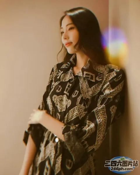 一个女人靠墙站着，双臂交叉