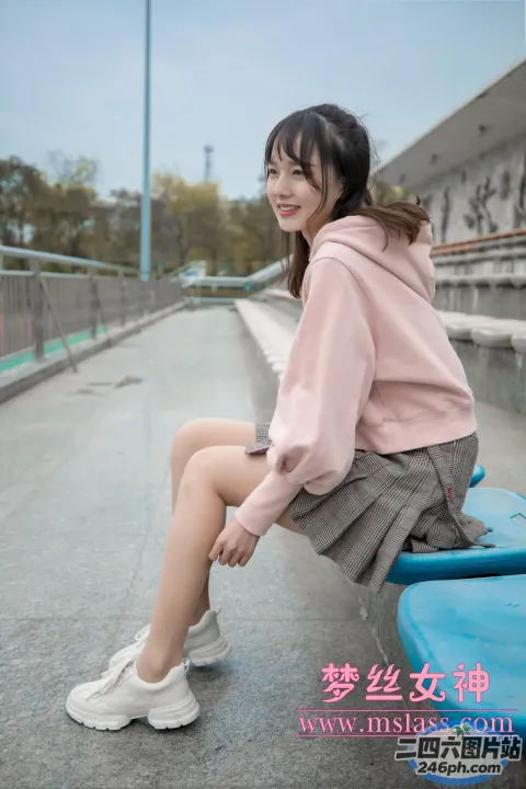 穿着粉红色运动衫和裙子坐在长凳上的 arafed 女人