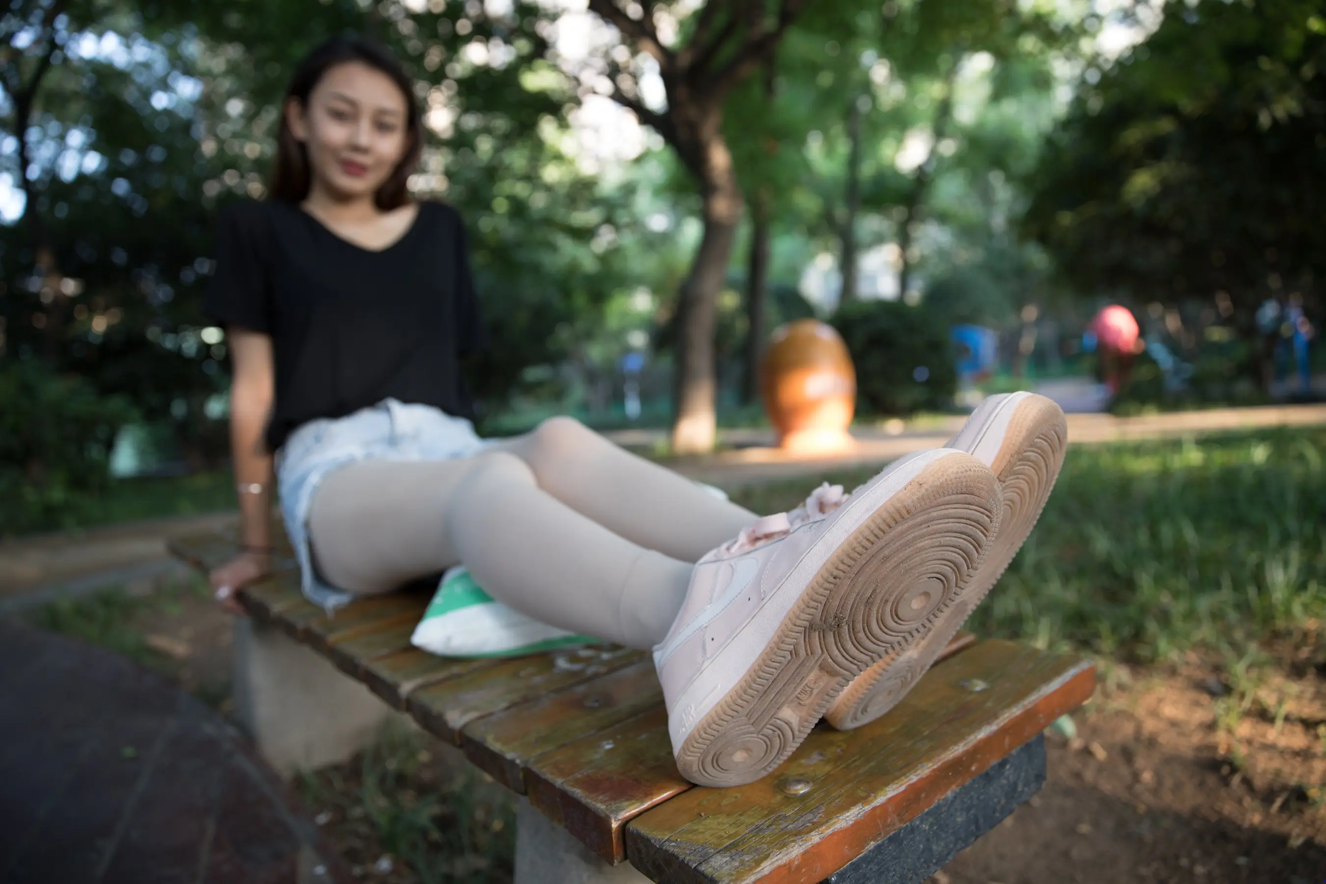 有个女人坐在长凳上，双腿交叉