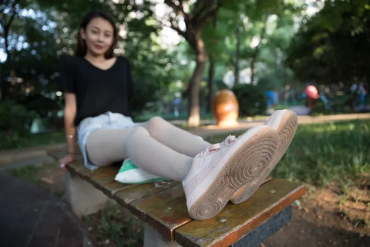 有个女人坐在长凳上，双腿交叉