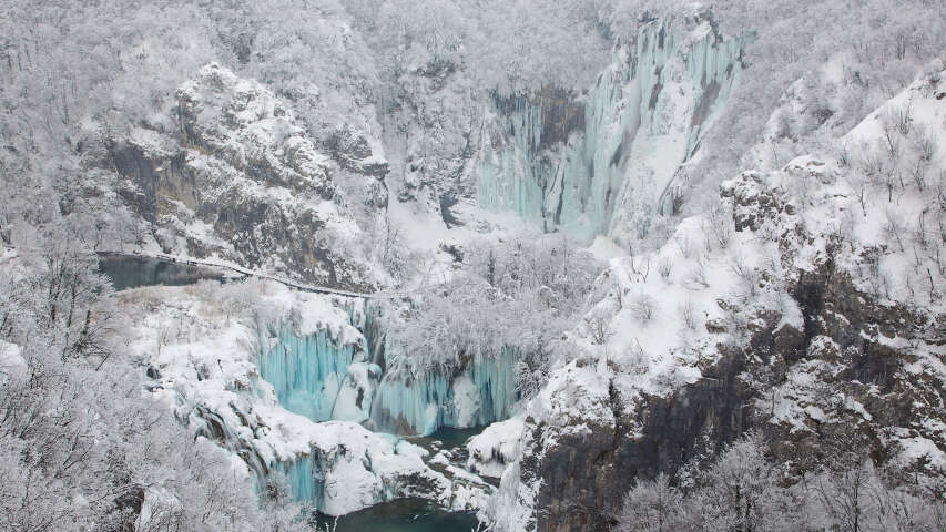 阿拉伯人站在白雪皑皑的山坡上，有瀑布