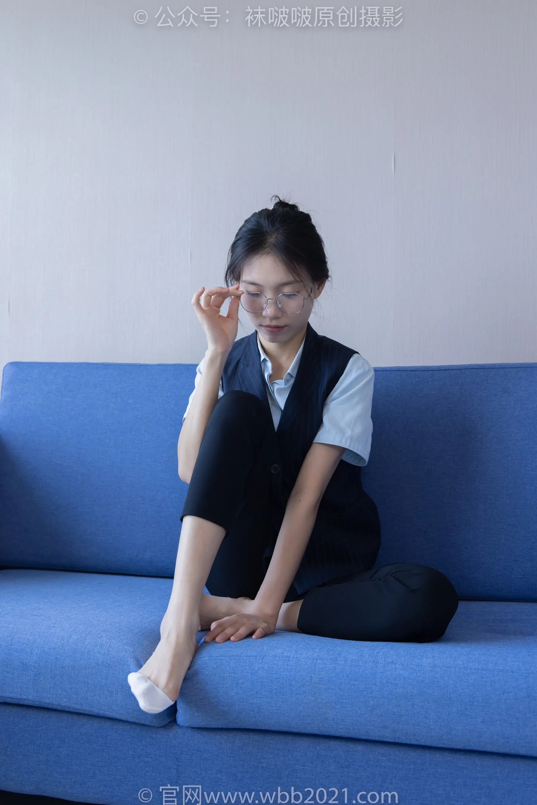 阿拉夫德女人坐在蓝色沙发上，双腿交叉